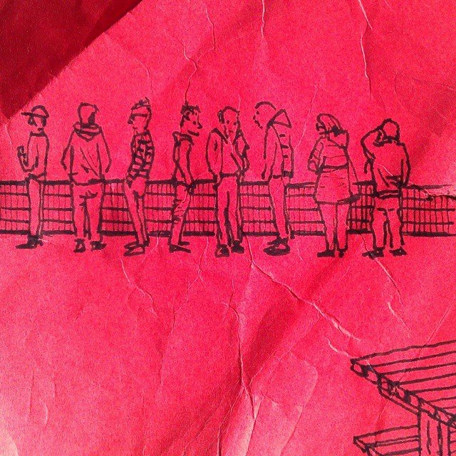 Kleine tekening van ouders langs de lijn bij het voetbalveld, op rood papier.
