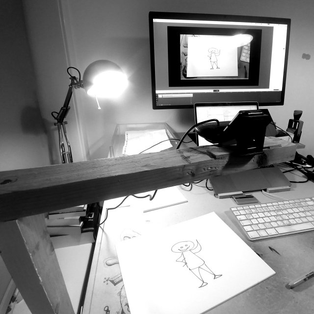 photo of my desk with a webcam on an improvised wooden arm, pointing down at paper. The drawing is seen on the computer monitor as well.